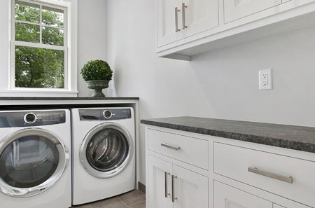 Refreshed laundry room in Lake Norman featuring newly refaced white cabinetry and organized storage