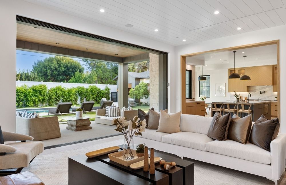 Stylish living room with modern kitchen and outdoor patio area, showcasing home renovation design