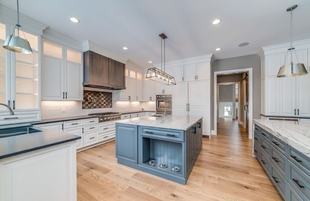 Newly remodeled kitchen in Schaumburg with white cabinetry, a blue island, and stainless steel appliances