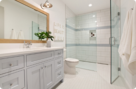 Stylish bathroom remodel featuring a walk-in shower with tile accents, a white vanity, and modern in St. George.