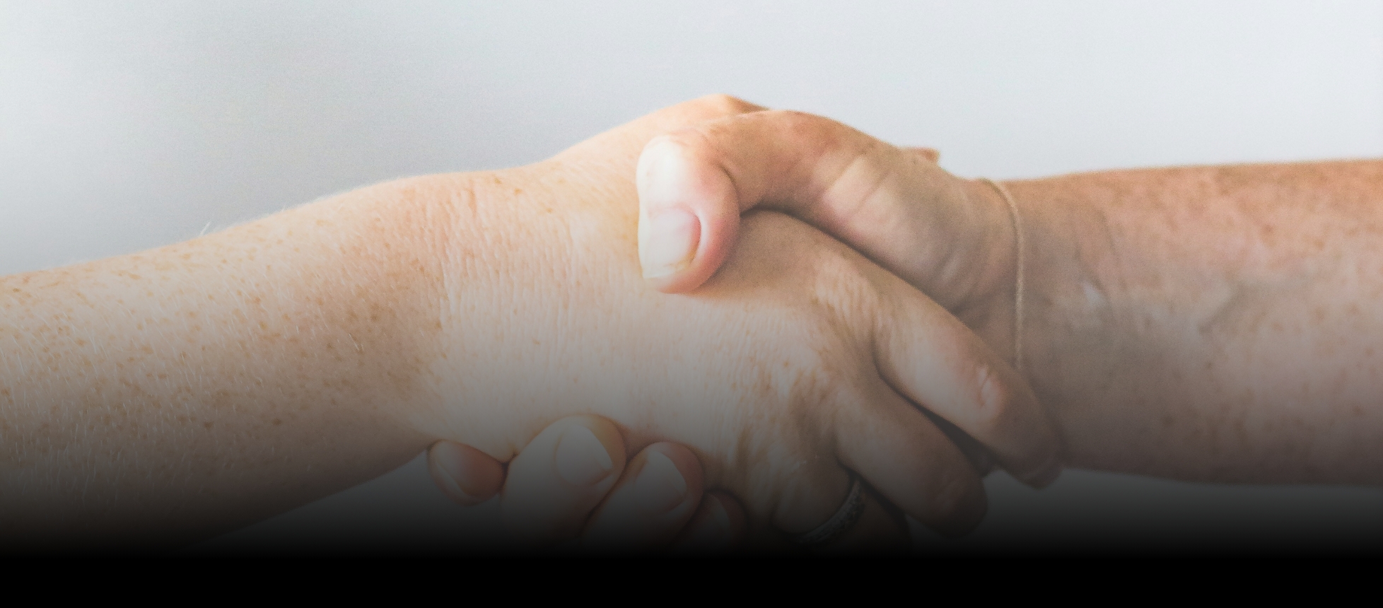 Close-up of a handshake symbolizing collaboration and building relationships within the DreamMaker Bath & Kitchen