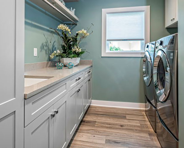 DreamMaker Bath & Kitchen laundry room remodel featuring white cabinetry, countertop, and modern appliances in St. Louis Park