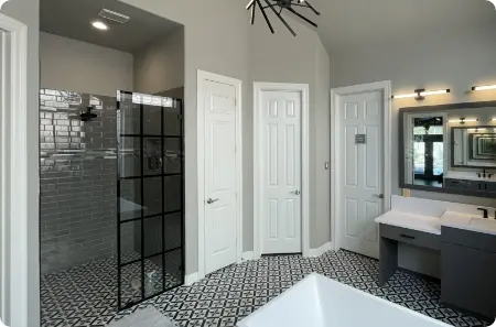 Accessible bathroom in The Woodlands, featuring a curbless glass shower enclosure and freestanding tub