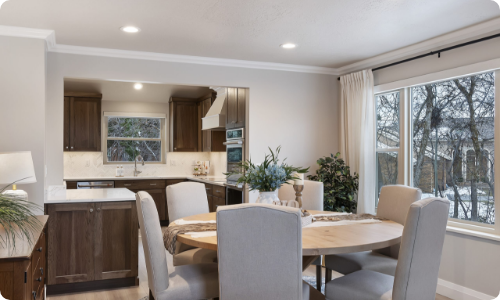 Elegant dining area and kitchen remodel featuring wood cabinetry and a large window overlooking in Yavapai